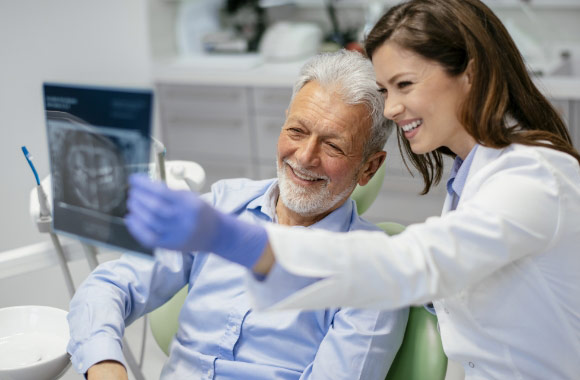 Smiling Patient Looking at Xray with Dentist 1