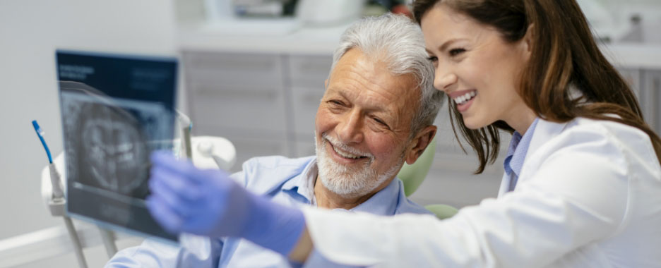 Smiling Patient Looking at Xray with Dentist