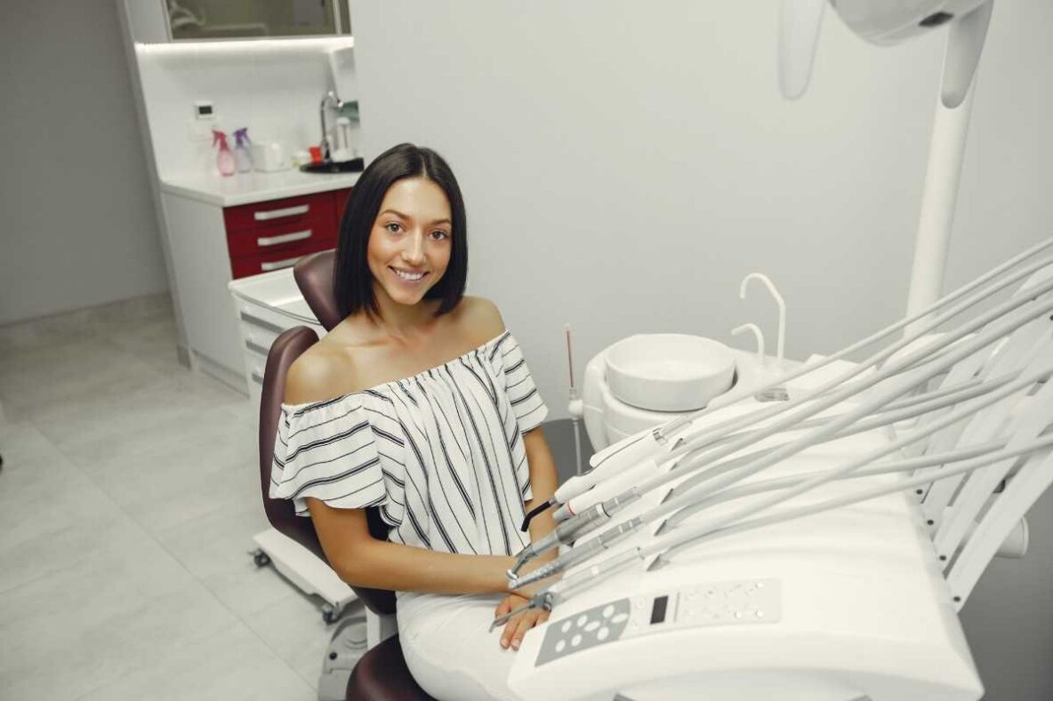 Happy patient seated in a dental chair after a full mouth restoration consultation
