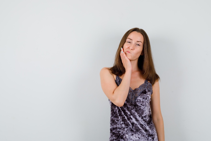 Girl with tooth pain holding her cheek
